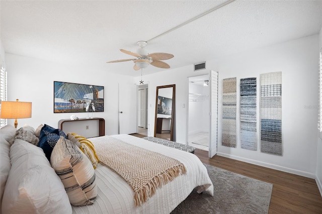 bedroom featuring a spacious closet, ceiling fan, dark wood-type flooring, and a closet