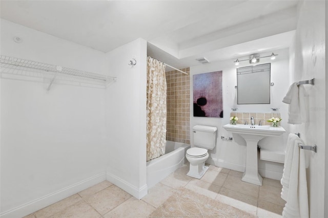 bathroom featuring tile patterned flooring, shower / tub combo, and toilet