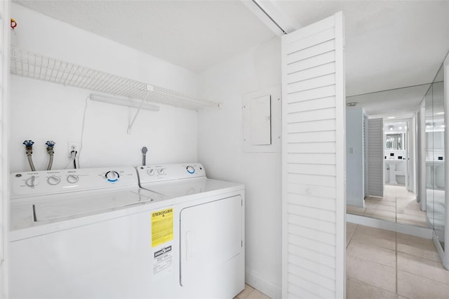 laundry room with light tile patterned floors, electric panel, and washer and dryer