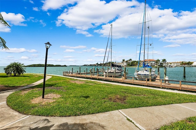 dock area with a lawn and a water view