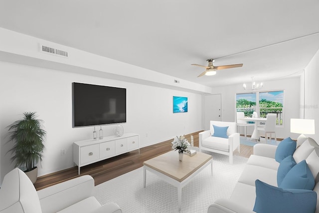 living room with dark wood-type flooring and ceiling fan with notable chandelier