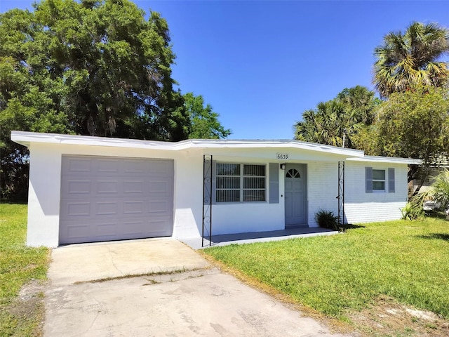 single story home featuring a porch, a garage, and a front lawn