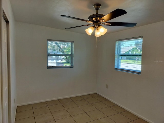 tiled empty room featuring ceiling fan