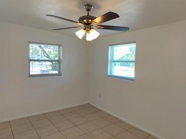 empty room with ceiling fan and light tile patterned floors