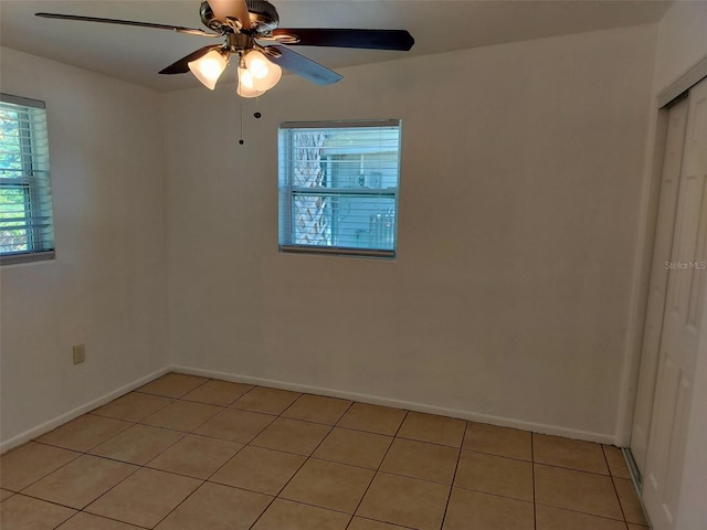 unfurnished room with ceiling fan and light tile patterned flooring