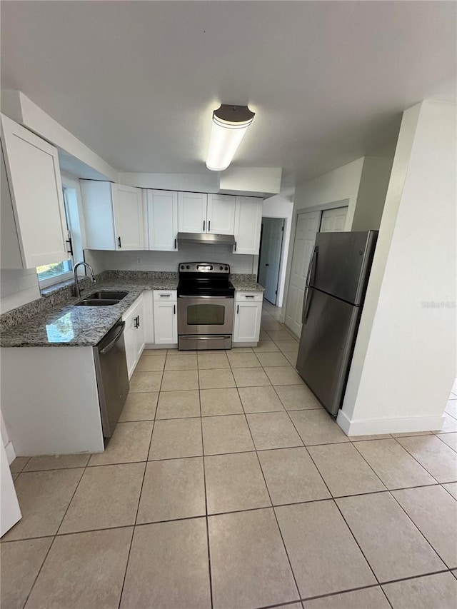 kitchen with sink, white cabinetry, stainless steel appliances, and dark stone counters