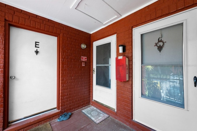 view of exterior entry featuring brick siding