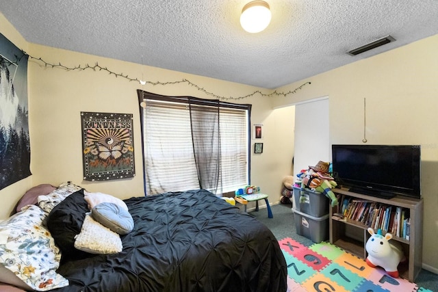 carpeted bedroom featuring a textured ceiling