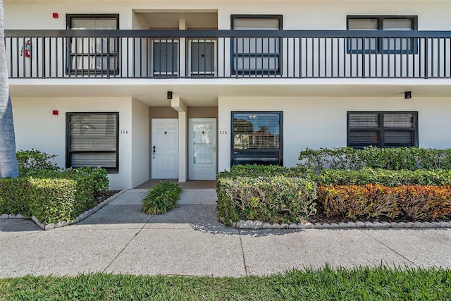 view of exterior entry with a balcony