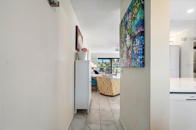 corridor with light tile floors and a textured ceiling