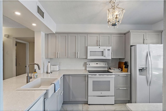 kitchen featuring a notable chandelier, white appliances, light tile flooring, and gray cabinets