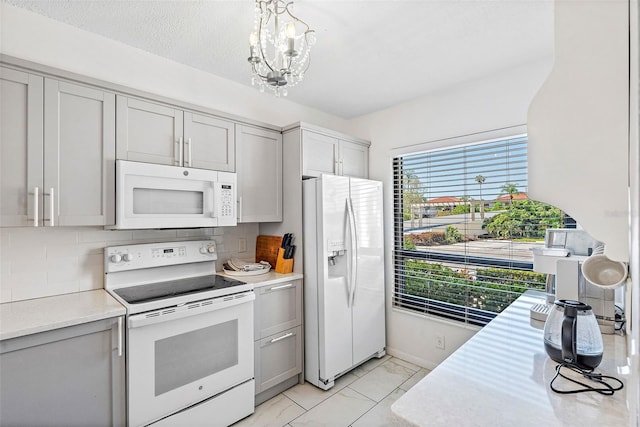 kitchen featuring gray cabinets, white appliances, tasteful backsplash, and light tile floors