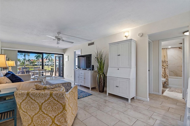 tiled living room featuring a textured ceiling and ceiling fan