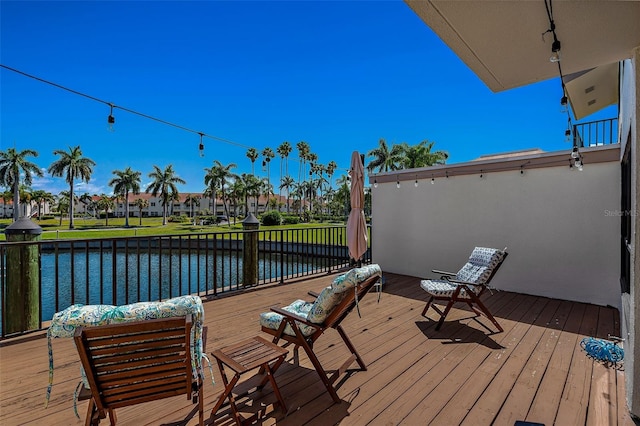 wooden deck with a yard and a water view