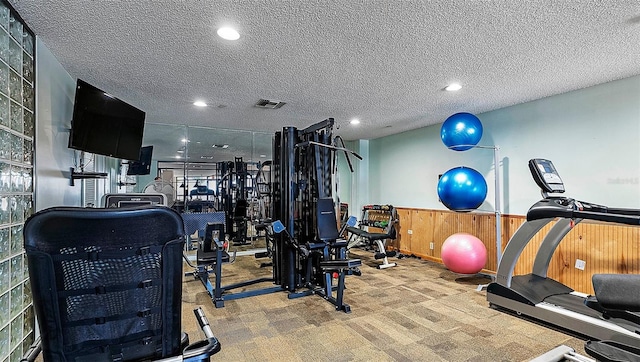 exercise room featuring carpet and a textured ceiling