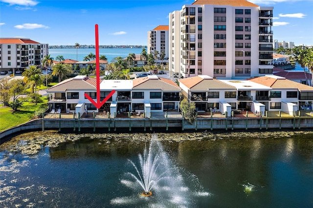 rear view of property with a balcony and a water view