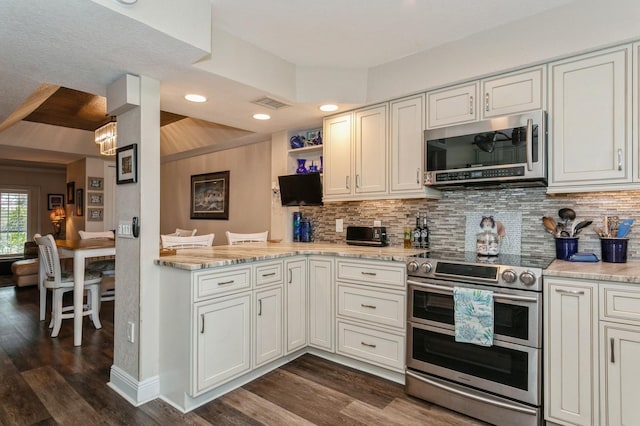 kitchen with tasteful backsplash, appliances with stainless steel finishes, dark hardwood / wood-style floors, and light stone countertops