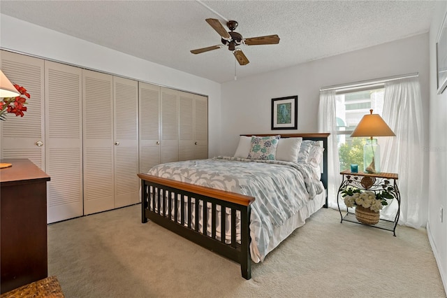 carpeted bedroom featuring a closet, ceiling fan, and a textured ceiling