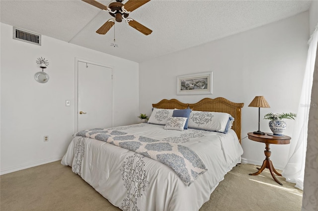 carpeted bedroom with a textured ceiling and ceiling fan