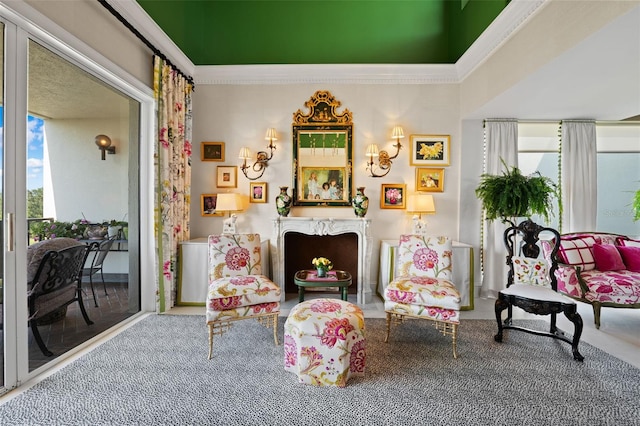 living area with a healthy amount of sunlight, carpet, and ornamental molding