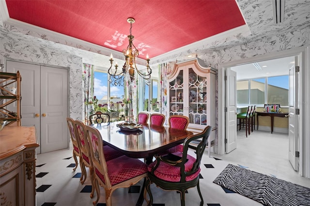 dining area featuring a tray ceiling and a chandelier