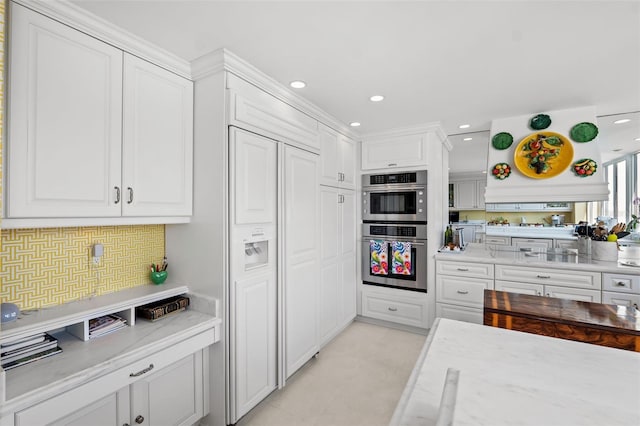 kitchen with backsplash, light tile floors, paneled built in refrigerator, white cabinetry, and double oven