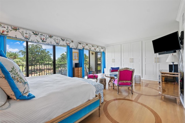 bedroom with access to outside, light hardwood / wood-style floors, and crown molding