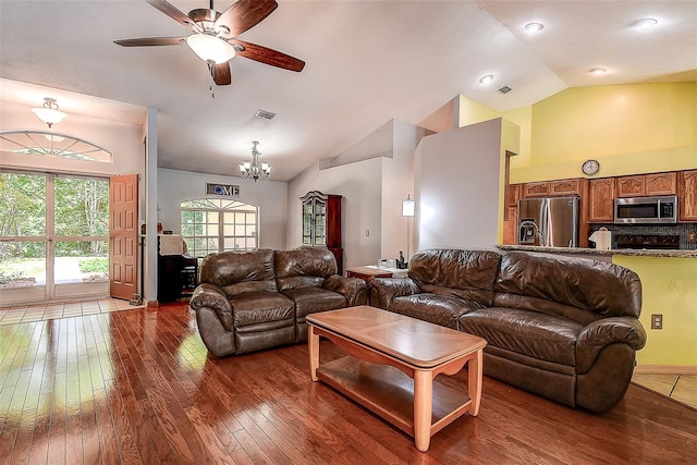 living room featuring dark hardwood / wood-style flooring, ceiling fan with notable chandelier, and lofted ceiling