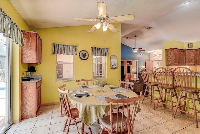 dining space featuring ceiling fan, lofted ceiling, and light tile floors