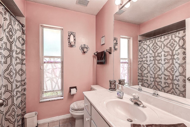 bathroom with tile flooring, toilet, a textured ceiling, and large vanity