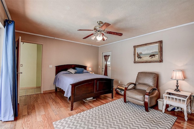 bedroom with ceiling fan, ornamental molding, and wood-type flooring