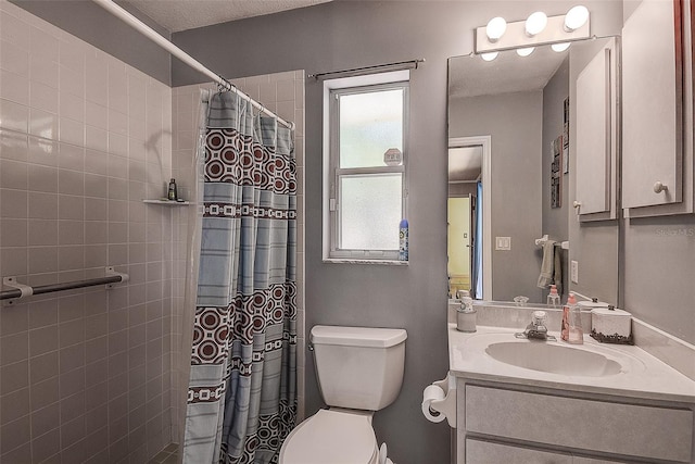 bathroom featuring a wealth of natural light, toilet, and vanity with extensive cabinet space