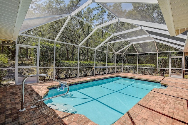 view of pool featuring glass enclosure and a patio area