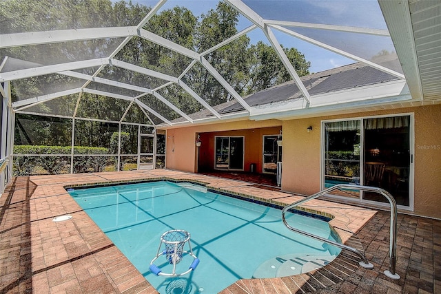 view of swimming pool featuring glass enclosure and a patio area