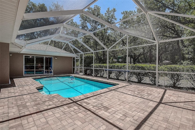 view of pool with glass enclosure and a patio area