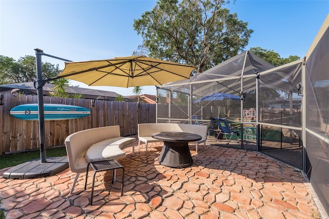 view of patio / terrace with glass enclosure and an outdoor fire pit