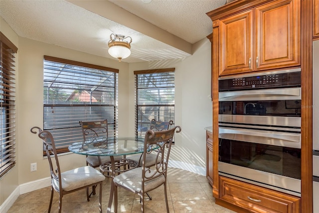 tiled dining room featuring a textured ceiling