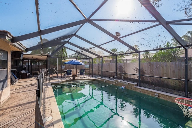 view of swimming pool with a patio and glass enclosure