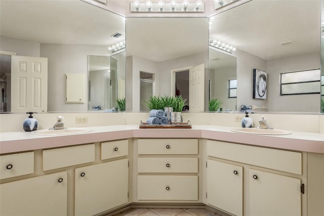 bathroom with tile patterned flooring, vanity, and a textured ceiling