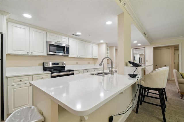 kitchen with sink, appliances with stainless steel finishes, a center island with sink, white cabinets, and carpet floors