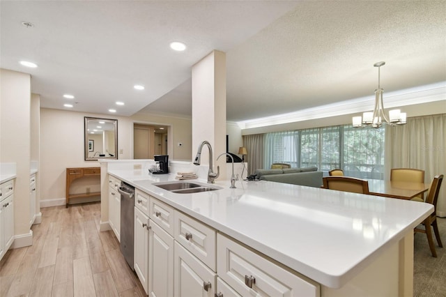 kitchen with pendant lighting, white cabinetry, a center island with sink, stainless steel dishwasher, and sink