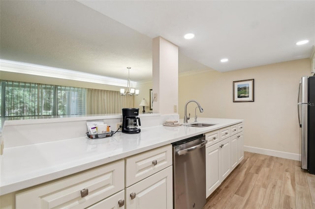 kitchen with appliances with stainless steel finishes, light hardwood / wood-style floors, white cabinetry, sink, and ornamental molding