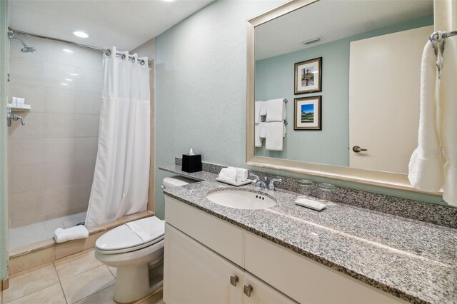 bathroom featuring curtained shower, vanity, tile floors, and toilet