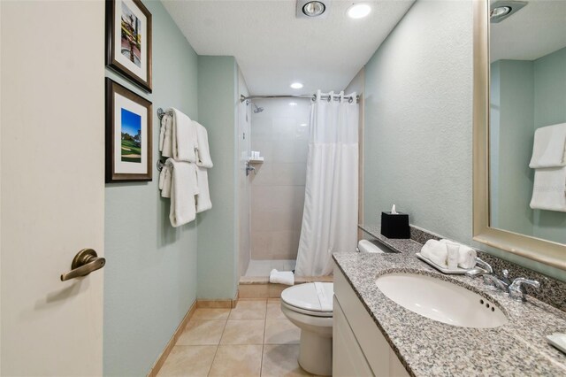 bathroom featuring curtained shower, toilet, a textured ceiling, vanity, and tile floors