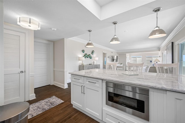 kitchen with light stone countertops, dark hardwood / wood-style flooring, ornamental molding, decorative light fixtures, and white cabinetry