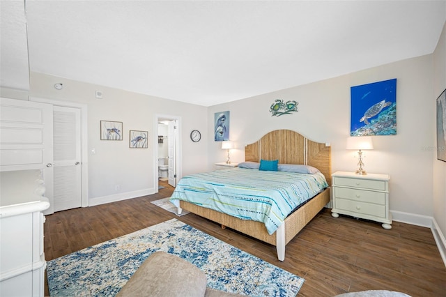 bedroom with ensuite bath and dark wood-type flooring