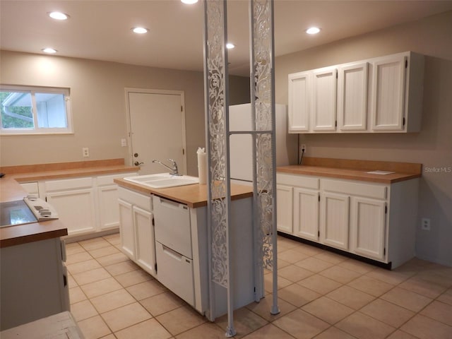 kitchen featuring dishwasher, light tile patterned floors, white cabinetry, and sink