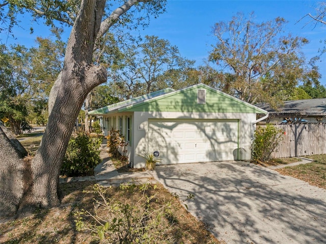 view of front of home featuring a garage, driveway, and fence