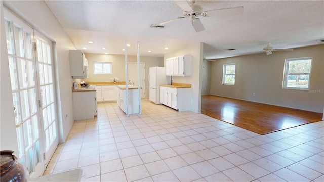 kitchen featuring white appliances, light tile patterned floors, visible vents, and open floor plan