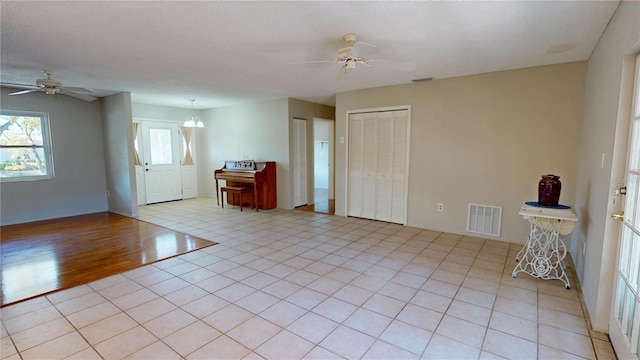 entrance foyer featuring a ceiling fan, visible vents, and light tile patterned floors